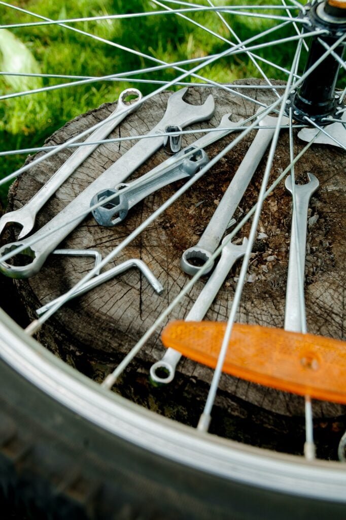 Tools, instrument for repairing bike on the wooden background outdoor wheel. Bicycle repair.